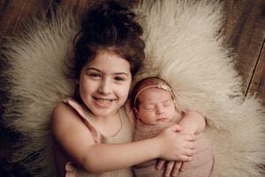 Adelaide newborn baby photographer's photo of a newborn baby with her big sister.