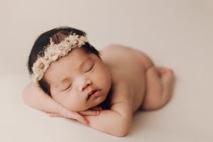 Adelaide newborn baby photographer's photo of a newborn baby girl on a cream backdrop.