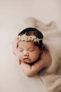 Adelaide newborn baby photographer's photo of a newborn baby girl on a cream backdrop.