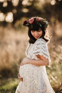 Adelaide maternity photograph of a pregnant woman in a white lace dress.