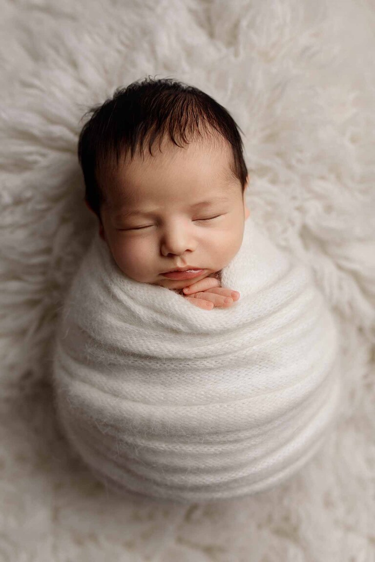Adelaide newborn baby photographer's photo of a newborn baby boy wrapped up in white.