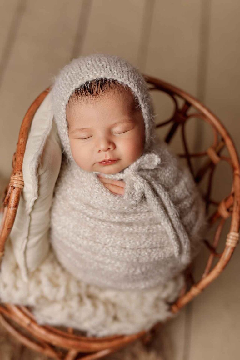 Adelaide newborn baby photographer's photo of a newborn baby boy wrapped up on a chair.