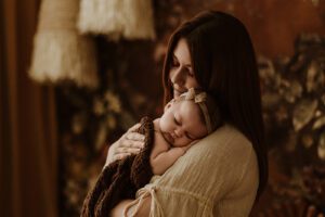 A mum cuddling with her 12 week old baby girl in an Adelaide newborn studio.