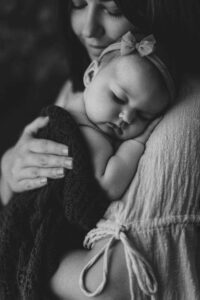 A mum cuddling with her 12 week old baby girl in an Adelaide newborn studio.