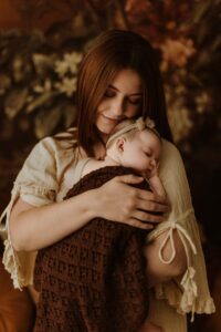 A mum cuddling with her 12 week old baby girl in an Adelaide newborn studio.