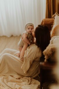 An Adeliade mum holding up her 12 week old baby and giving her a kiss.